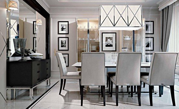 This picture shows a black and white, spotted cat standing on the edge of a bathtub, looking down into the tub. The cat has its front paws on the rim of the tub, looking curiously at what might be inside.