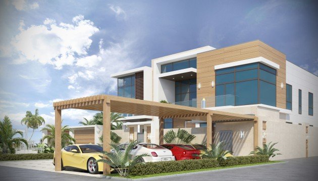 This picture shows a large, white, two-story house with a brick chimney and wood siding. There is a two-car garage on the left side, and a second smaller building to the right of the house. The front has a large porch and multiple trees and shrubs in the foreground.