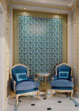 The picture shows a white plant pot with a green foliage plant inside. The pot sits on a wooden table and is adorned with a blue ribbon and a bow.