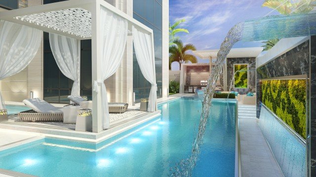 This picture shows a large, rocky mountain range with several snow-covered peaks and vast forests of pine trees. The sky is blue with white clouds in the background, and the sun is casting a bright light on the landscape. The snow has accumulated between the peaks and is visible in the shadows of the valleys.