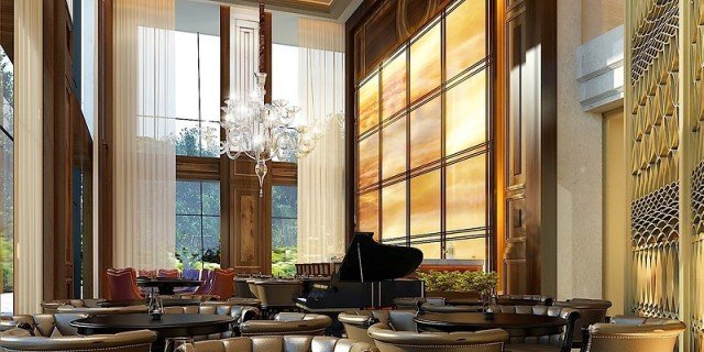 The picture shows a large, grey and white Great Dane with his head resting on the arm of someone who appears to be his owner. They are both sitting in a white backyard chair outside with a grassy backdrop.