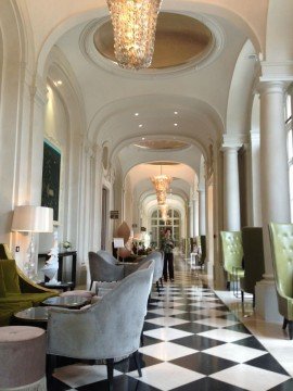 A modern outdoor terrace featuring a combination of white seating with natural stone and grass elements.