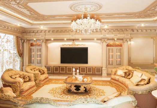 This picture shows a man jumping into a swimming pool. He is wearing a black and white striped swimsuit and has his arms out at his sides in an aerodynamic position as he jumps towards the water. The pool is blue and lined with tiles, and there are towels laid on the side of the pool next to some beach chairs.