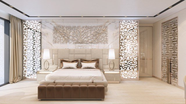 This picture is of a luxurious bedroom in an elegant home. The bedroom features a dark wooden queen-sized bed with a tufted headboard, a white nightstand with a matching lamp, and a dresser with drawers finished in a soft gray color. The walls are painted in a warm beige tone and decorated with sophisticated framed artwork. The room has a cozy atmosphere created by a grey area rug and two beige armchairs placed near the large window.