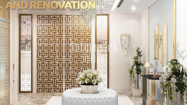 The picture shows a luxurious bathroom with a large white marble bathtub at the center. There are two white chairs on either side of the tub, and on the wall to the right is a beautiful chandelier. The walls and floors are lined in marble, and a large window lets natural light into the space.