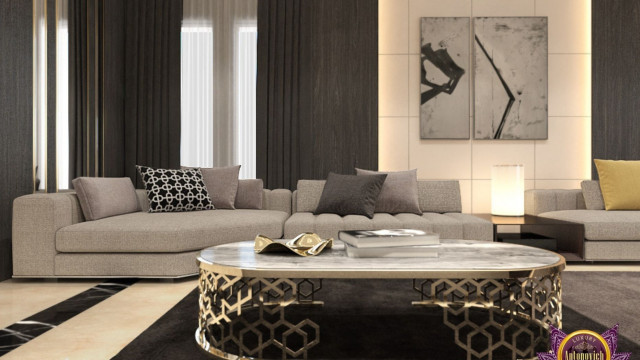 Modern and luxurious bedroom showcasing a king size bed with monochromatic headboard, stylish armchairs on the side, a grey area rug, and gold-accented side table.