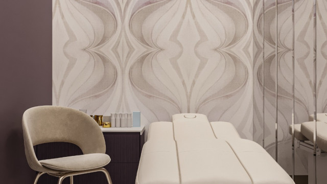 This picture shows a spacious and modern living room with luxurious furniture. The room is decorated in a contemporary style, with a white marble floor, light grey walls, and a large black leather sectional sofa that faces a white marble fireplace. There is also an ornate chandelier and decorative accents throughout the room.