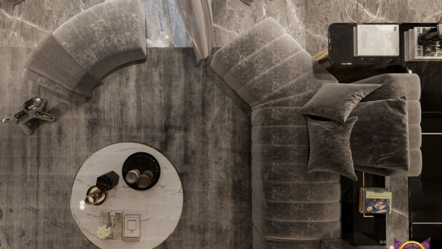 A contemporary interior featuring a white sofa, armchair, and coffee table in an open plan space with glass walls.