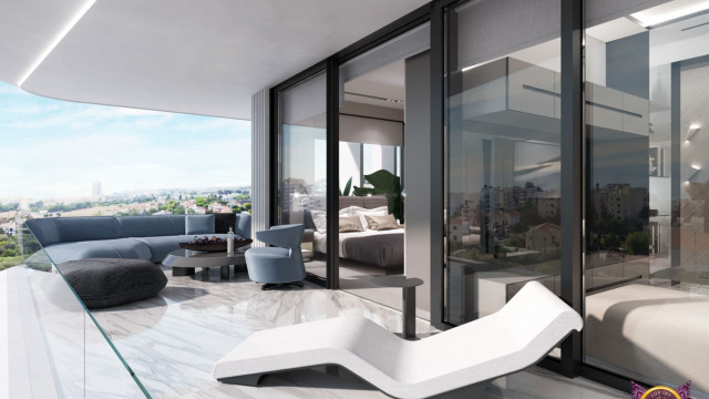 This image shows off a classic living room design with a modern twist. The room features a beige sofa with light blue accent pillows, a white armchair, and an elegant black coffee table. The walls are painted in a light gray shade and accessorized with framed artwork and a large silver mirror. The room also has a luxurious chandelier as a centerpiece creating a warm and inviting atmosphere.
