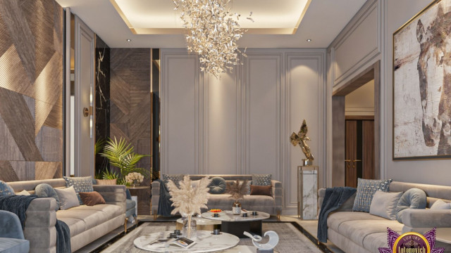 This image shows a luxurious living room with elegant decor. The focal point of the room is the large white marble fireplace with intricate inlaid gold detailing. To the left of the fireplace sits two comfortable sofas facing each other, with two patterned armchairs filling the space between them. The floor is covered in a light beige carpet, and there is an elaborately patterned rug beneath the furniture. On the right side of the room are large floor-to-ceiling windows, providing an abundance of natural light. The overall look is one of tasteful refinement and comfort