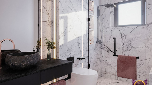 This picture shows a modern, luxury bedroom decor. The room features a large bed with white upholstered headboard, a round nightstand with matching lamp, and two velvet armchairs in a light grey hue. The walls and ceiling are painted a light shade of grey, while the floors are a dark hardwood. The room is decorated with wall art, a large rug, and various decorative objects.