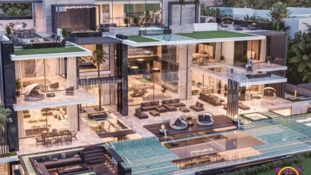 The picture shows a luxurious living room setting, featuring a grand piano and seating area. The walls and furniture in the room are decorated with white and gold accents, giving off an opulent and sophisticated feel. The large, arched windows allow for plenty of natural light, while the hardwood floor adds to the luxurious atmosphere. A large chandelier hangs from the ceiling, adding a touch of glamour and elegance to the space.