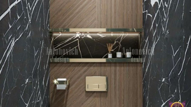 This picture shows a luxurious living room with a striking beige and brown color palette. The room features an elegant cream-colored sofa with two matching armchairs arranged around a glass-top coffee table. There is an ornately framed mirror above the couch and a pair of large windows on the right, letting in plenty of natural light. On the left side of the room, there is a grand fireplace with a mantelpiece decorated with a golden vase and candles. A round area rug in hues of chocolate and tan adorns the floor, while the walls are decorated with several pieces