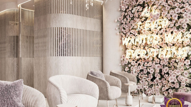 Modern luxury interior featuring a curved cream sofa, a black armchair and ottoman, a round marble coffee table, a patterned floor rug, and a large hanging chandelier.