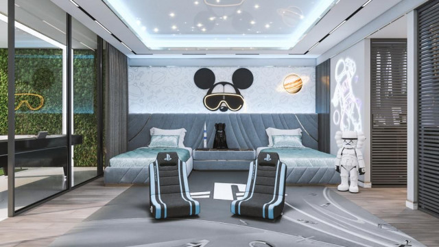 This picture shows a luxurious, contemporary style living room. It has high vaulted ceilings with chandeliers, large windows, and wood floors. The furniture is upholstered in white and beige colors, with dark wood accents. There is a fireplace with an art deco fireplace screen, modern wall art, and plants for decoration.