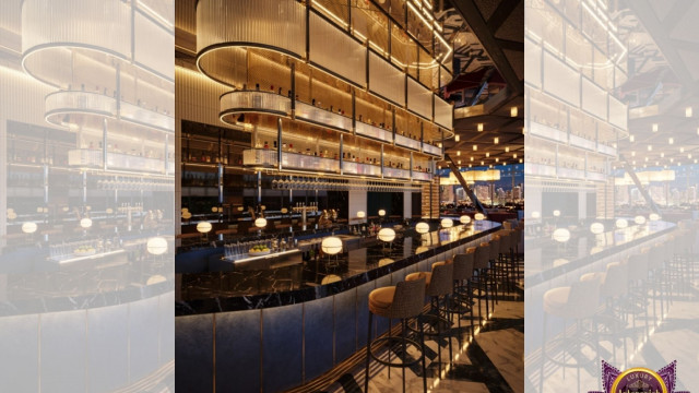This picture is showing an elegant and modern living room design created by Antonovich Design. The design features a black leather sectional sofa with white trim and a pink and purple accent chair situated around a white rectangular coffee table. A beige rug is displayed in the center of the room and a crystal chandelier hangs from the ceiling. The walls are painted a light grey and adorned with art canvases.
