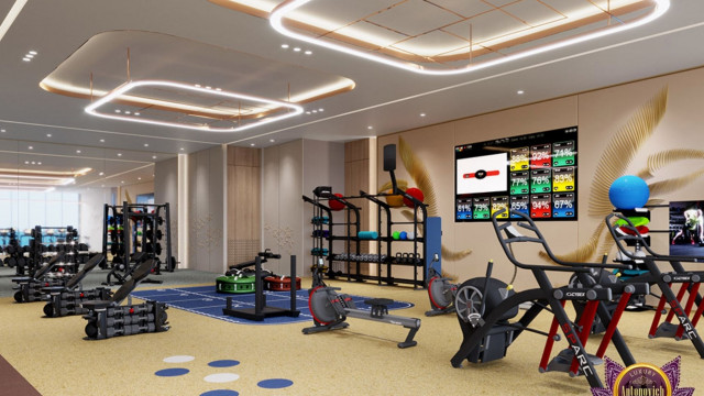 The picture shows an elegantly designed bedroom with a wooden bed adorned with blue and white bedding and two pillows. The walls are painted in a pale gray color and feature a geometric pattern wallpaper with a beige and white stripe. The floor is covered with a light gray rug, and the room has an armchair in the corner with a white and gray cushion. On either side of the bed are two nightstands with silver lamps, and a window with sheer curtains.