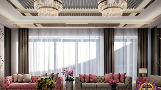 This picture shows a luxurious kitchen with a large marble countertop set against a sleek dark grey cabinet. The kitchen features modern, stainless steel appliances including a range hood, an oven, and a built-in refrigerator. There is also an island with a white countertop and multiple cabinets underneath, providing ample storage space. The room is illuminated by recessed lighting and a unique pendant light hanging from the ceiling.