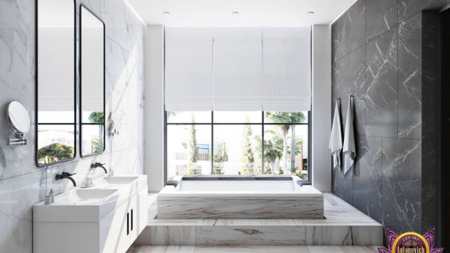 A large entryway featuring a tall double door with ornate carvings, flanked by two tall stone columns and an intricate stone arch.