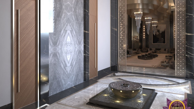 A luxurious bedroom interior consisting of a bed, nightstands, wall sconces, and other pieces of furniture upholstered in muted pastel colors.