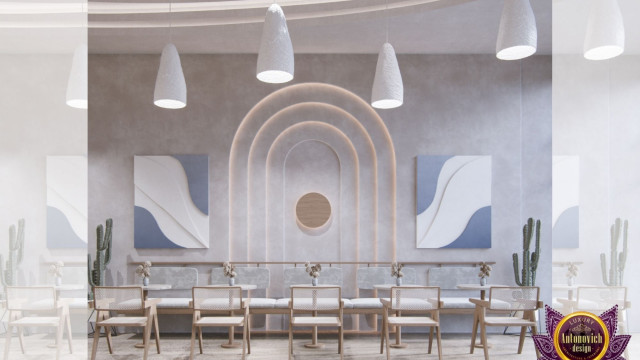 This picture depicts a modern and luxurious living room. The room is decorated with gold accents and marble walls. The large windows offer plenty of natural light and there are two comfortable, white sofas and a round glass coffee table in the center of the room. The walls are adorned with artworks and there is a stylish rug on the floor.