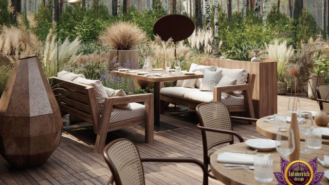 This picture shows an ornate and luxurious living room. It features a velvet sofa with a coral colored accent wall, several ornate mirrors hung on the walls, and various other pieces of furniture such as a coffee table, chairs, and side tables. On the left side of the image, there is a grand chandelier hanging from the ceiling, adding to the overall lavish feel of the room.