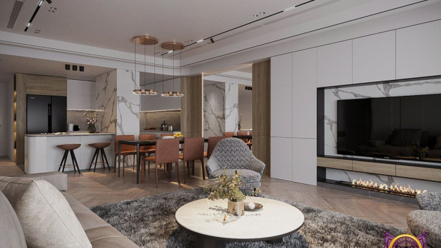 This picture shows an open-concept living space with a modern aesthetic. The space contains two gray sofas placed in an "L" shape, a glass coffee table, and a light gray rug. The walls are white and there is a large window, which lets in plenty of natural light. There is also a modern abstract painting hung on the wall, which adds a touch of color to the space.