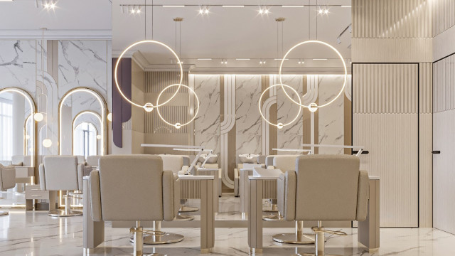 The picture shows a luxurious living room with a modern design. The walls are painted in a white color, and there is a grey comfortable sofa in the center of the room. There is also an ottoman in front of the sofa and a long glass table that serves as a coffee table. There are also two armchairs and a round glass table to the side of the sofa. The walls are decorated with wall-mounted paintings, adding an elegant and sophisticated look to the room.