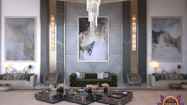 This picture is of an ornate, luxury staircase in a lobby. The stairway is made of white marble with a black stone handrail. The steps are decorated with golden ornaments and the balustrade is adorned with gold detailing. There is a large chandelier at the top of the stairs that adds to the opulent atmosphere.