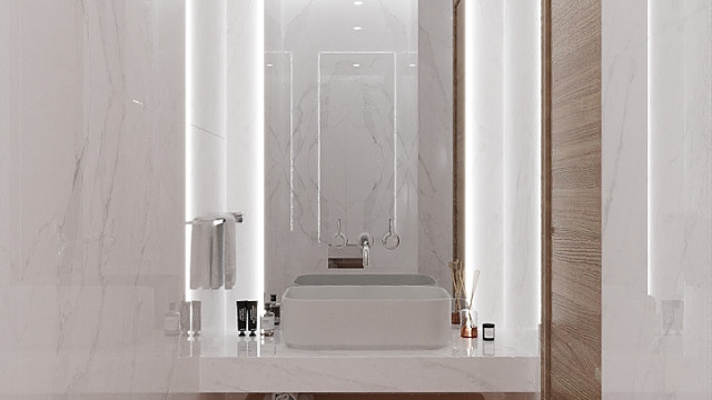 This picture shows a luxurious, modern living room designed by the firm Antonovich Design. The room features a large white sofa and ottoman with a statement mirror above it, along with stylish gray armchairs and a glass top coffee table. There is also an ornate rug and fireplace as well as a small display of decorative accessories on the shelves. The ceiling features a stunning chandelier and plenty of natural lighting coming in from the large windows.