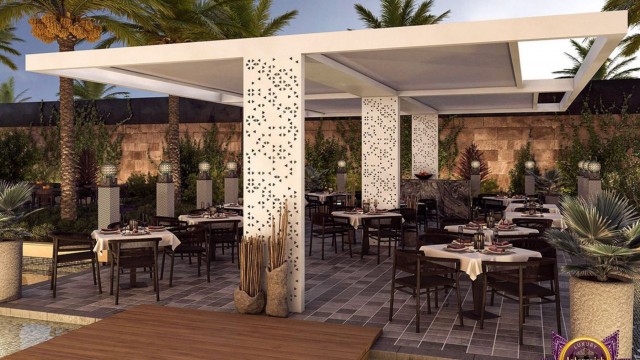 This picture shows a luxury living room designed by Antonovich Design. The room is decorated with rich blue velvet upholstery, intricate moldings and detailed woodwork. The walls are painted a neutral color and adorned with golden mirrors and golden frames with artwork, adding an opulent touch to the space. The furniture pieces in the room are a classic style, with a large sofa, two armchairs and a stunning chandelier hanging from the ceiling.