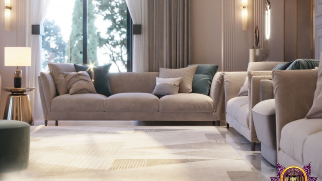 This picture is showing a luxurious bedroom interior designed by Antonovich Design. The room features a dramatic dark blue velvet bed with ornate detailing, subtly lit by crystal chandeliers. A large black fireplace stands in the corner, surrounded by elegant wall accents and artwork. The walls are painted in a deep navy blue color, with a coordinating patterned rug covering the floors.