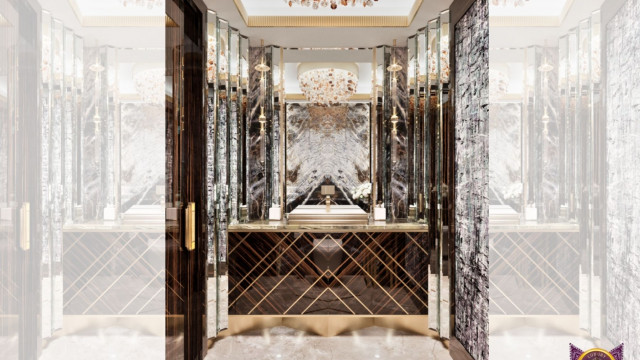 This picture shows an ornately decorated living space filled with antique furniture and grand furnishings. The walls are lined with luxurious striped wallpaper and the room is lit by two magnificent chandeliers. In the center of the room is a large, gray velvet sofa with two brown leather armchairs on either side. A mirrored console table sits behind the sofa, flanked by two tall antique vases. The entire scene is completed by a plush area rug that adds a touch of warmth to the room.