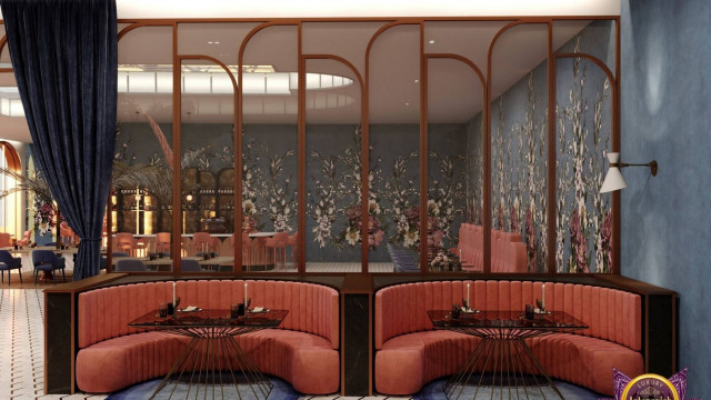 This picture shows a luxurious interior design that features a grand staircase with a curved marble balustrade. The staircase is accented by two exquisite chandeliers, which hang from a ceiling of intricate ceiling roses and white columns topped with gold capitals. The overall effect is one of opulence, elegance, and grandeur.