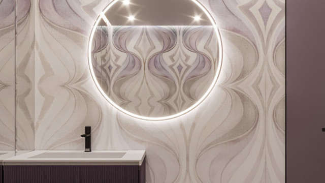 This picture appears to be a luxurious and contemporary lobby area with a sweeping marble staircase. The walls are lined with tall, gold-framed oil paintings and very high, rounded windows. There is a seating area with two velvet chairs, a round marble side table, and a circular mirror above the fireplace. The floors are inlaid with an intricate and eye-catching pattern of different varieties of marble.