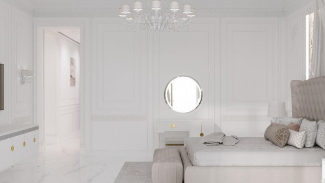 A modern interior featuring a curved sofa, a round marble-top coffee table, and a circular chandelier with multiple layers of hanging globes.