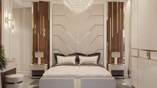 This picture shows a contemporary, minimalist living room designed by Antonovich Design. The room features a light gray sofa and armchairs with simple, muted accents, and a rug in the center of the room providing a pop of color. The walls and ceiling are painted white, while the floor is made up of dark-colored tiles. There is also a large window to the right of the room allowing natural light to flood in.