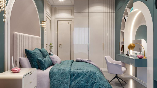 Red velvet three-seat sofa with gold accents and intricate patterns, placed on a patterned rug in a room with white walls and door.