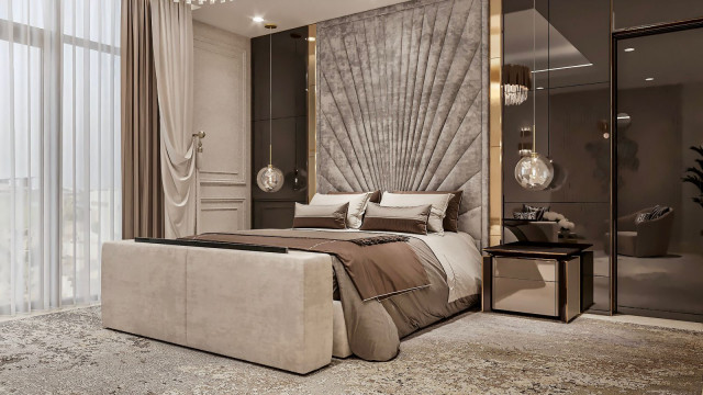 This picture shows a luxurious living room with a grand piano, two large beige sofas, and several armchairs arranged around a large fireplace. There is a large window to the right, letting in plenty of natural light. On either side of the fireplace are floor-to-ceiling shelves filled with books. The walls and ceiling are ornately decorated with intricate details and a grand chandelier hangs from the center of the room.