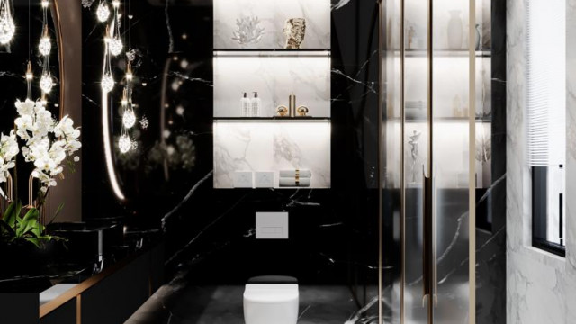 This picture shows a luxurious modern living room with a comfortable elegant sofa and armchair, set in front of a statement wall with a recessed fireplace. The black marble floor and walls are complemented by the grey furniture upholstery and white panel walls, creating a chic and sophisticated atmosphere. There is a coffee table and sideboard in the corner, as well as artwork and decorative accessories, bringing the whole look together.