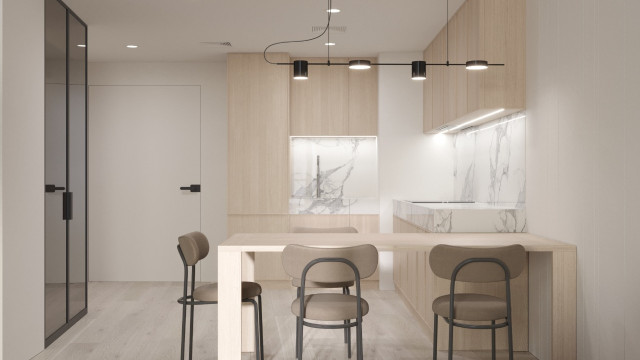 Luxuriously designed living room with seating area consisting of velvet tufted armchairs and an ornate carved armchair, positioned around a round glass top coffee table. The walls are adorned with an elegantly detailed wallpaper, and the floor is finished with a plush pale carpet, illuminated by a chandelier.