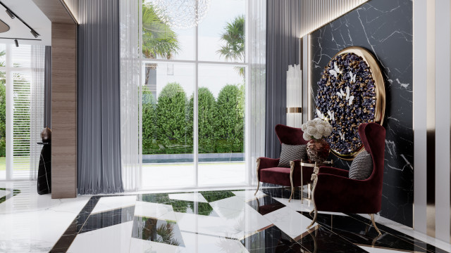 This picture shows a modern bedroom interior design. The room features two teal blue chairs on the left side, while a large white leather sofa with a geometric pattern is situated against the right wall. A framed abstract painting is hanging above the sofa, and there is a glass and chrome coffee table in between the two seating areas. Dark gray walls and light gray accents create a cohesive look, while recessed lighting illuminates the space.