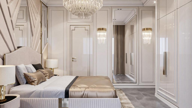 This picture shows a modern interior design. It includes a sleek black sofa, white and black accent chairs, a contemporary dining table, and white floor-to-ceiling curtains that open up to a large balcony. The walls are painted a light grey color, and there is an elegant crystal chandelier hanging from the ceiling. The lighting in the room is warm and inviting, perfect for relaxing after a long day.