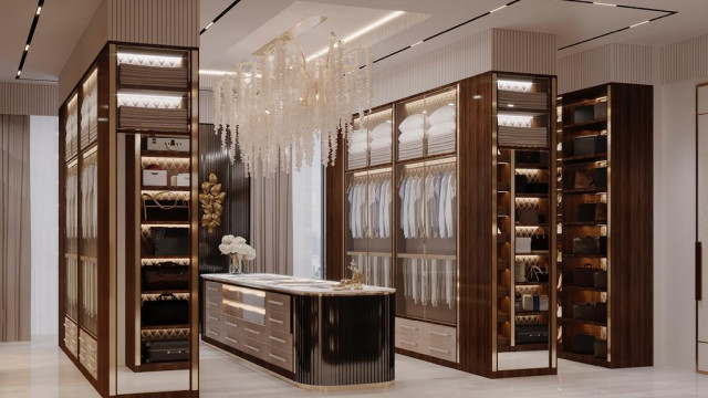 This picture shows a modern and luxurious light-filled living room with a curved white sofa and coffee table. The walls are a neutral grey with floor-to-ceiling windows providing lots of natural light. There is an abstract art piece on the wall and plants scattered throughout the room, adding to the contemporary feel.