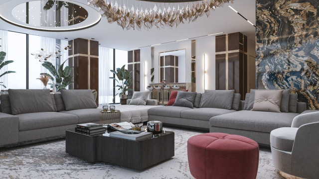 A multi-level lobby featuring a central chandelier hung from an ornate, coffered ceiling with cream-colored walls and marble accents.