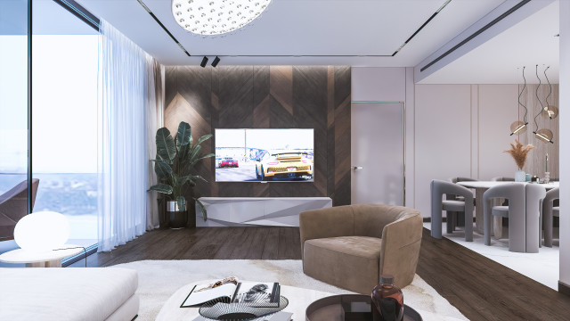 Modern bedroom with grey and white furnishings, including a four-poster bed, upholstered armchairs, chaise longue, side tables, and mirrored dresser.