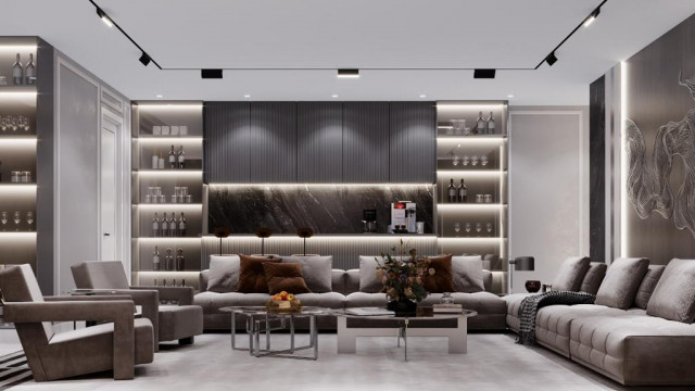 Modern interior with large open plan living area featuring a central sofa set in double-sided configuration, a large dining table with chairs, and a contemporary stone wall feature.