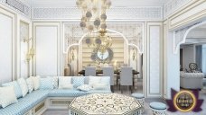 The picture shows a person wearing a black and white striped jersey with blue jeans. They are also wearing a matching black and white baseball cap and white sneakers. The person is standing in the middle of a room with white walls, concrete floors and grey furniture.